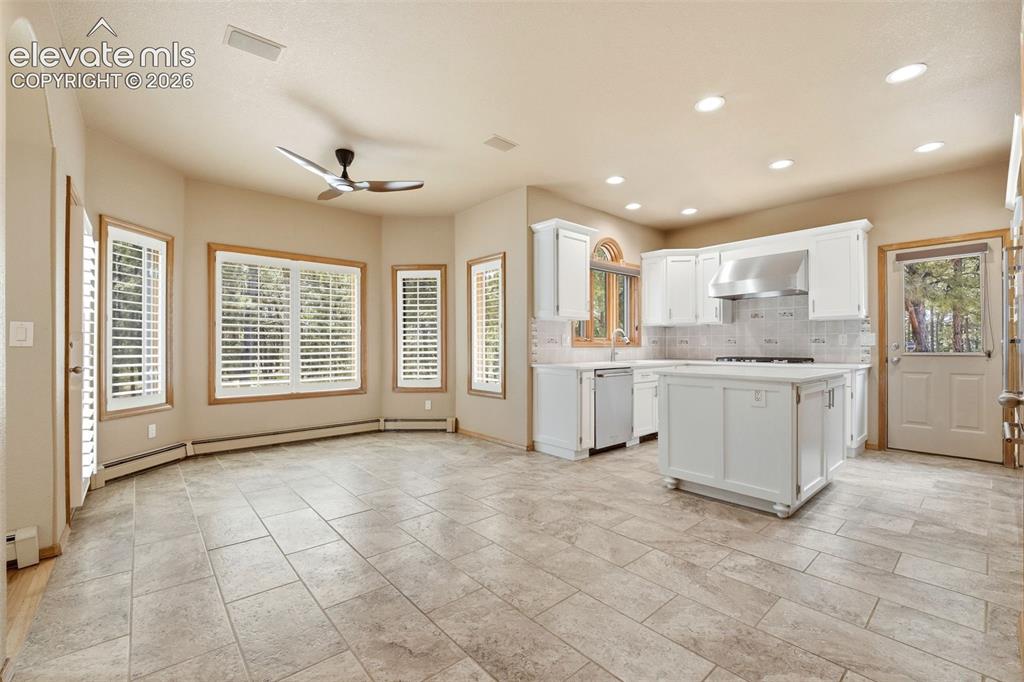 Image 3 of 40: Open-concept kitchen and living area featuring tile flooring, white cabinet