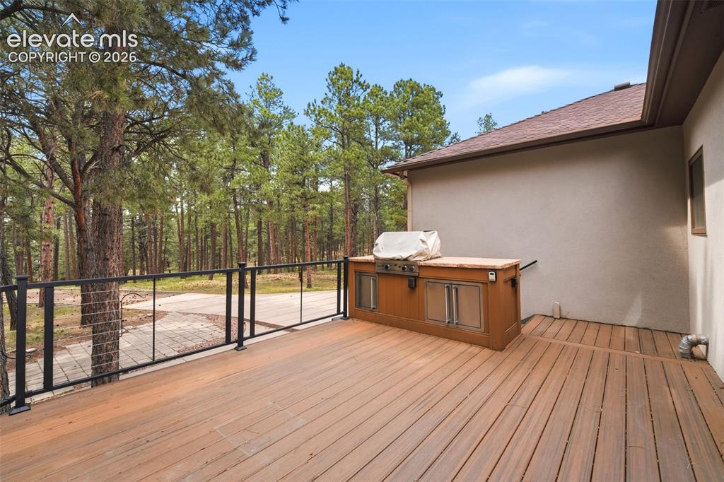 Image 34 of 40: Expansive outdoor deck featuring wood-finish flooring, a contemporary black
