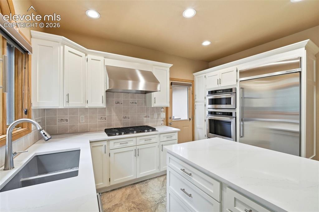 Image 5 of 40: Kitchen featuring white cabinetry, stainless steel appliances, a gas cookto