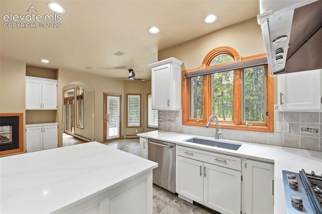 Image 7 of 40: Modern kitchen featuring a large island with a light-toned countertop