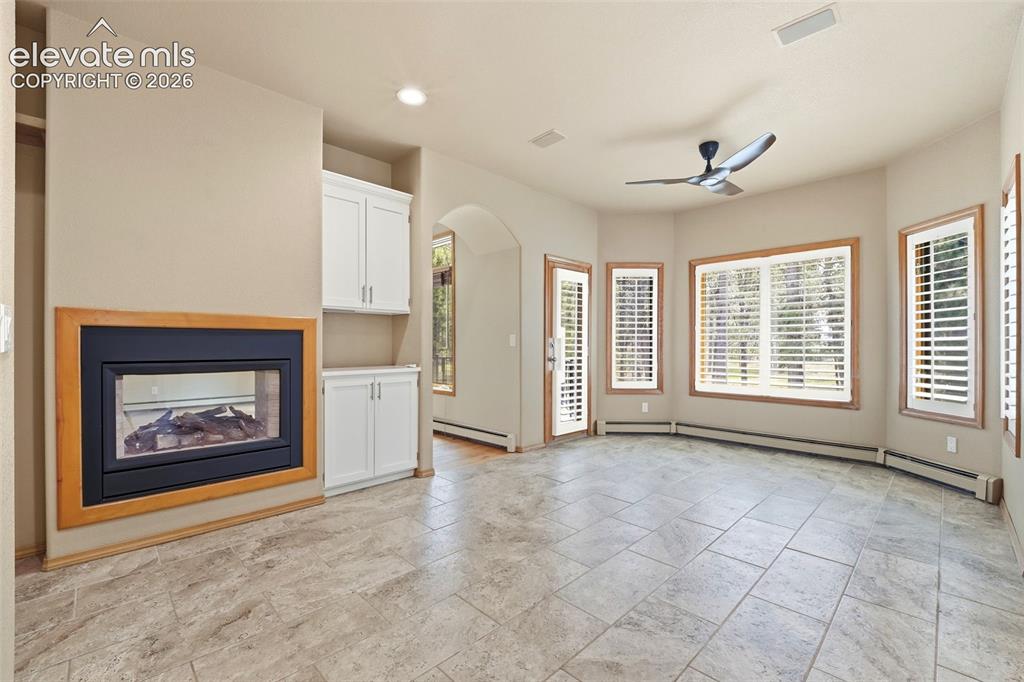 Image 9 of 40: Spacious room featuring tile flooring, a built-in fireplace with a wood fra