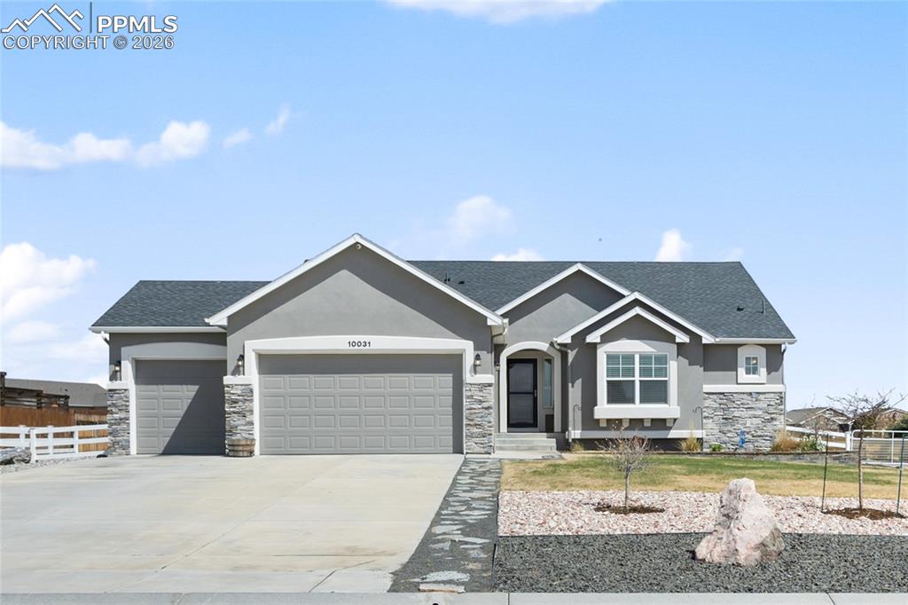 Caption: Contemporary ranch-style residence featuring a gray stucco exterior with stone accents