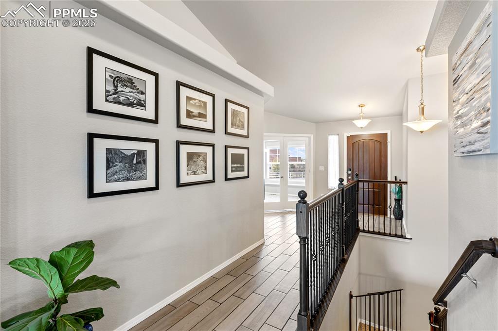 Image 10 of 41: Entryway featuring ceramic tile flooring, a dark wood front door, and a ban