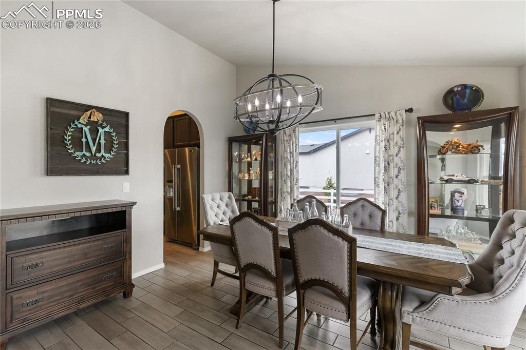 Image 14 of 41: Spacious dining area featuring an arched doorway and a contemporary chandel