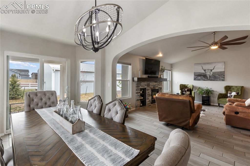 Image 15 of 41: Dining area featuring a contemporary chandelier, opening to a living area w