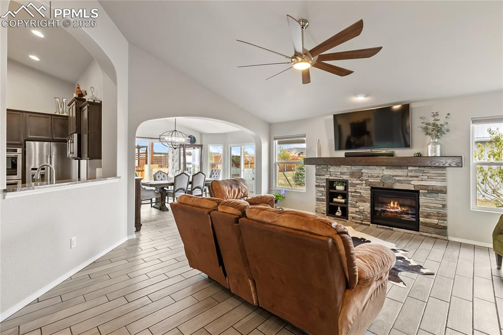 Image 16 of 41: Living area featuring a stacked stone fireplace with an integrated mantel a