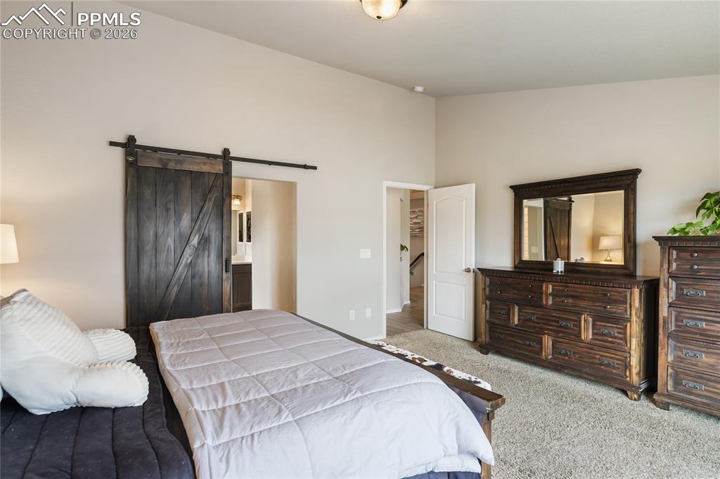 Image 20 of 41: Spacious primary bedroom featuring vaulted ceilings, a large window, and so