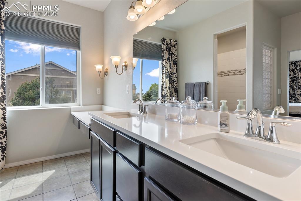 Image 21 of 41: Spacious primary bathroom with dual vanities and connected walk-in closet