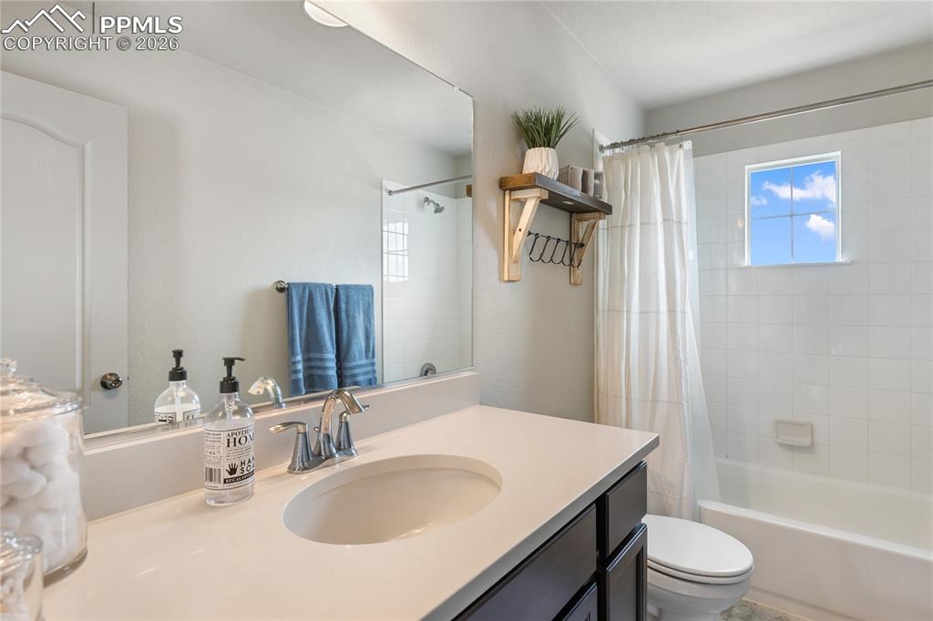 Image 24 of 41: Bathroom featuring a single vanity with an integrated sink, polished chrome