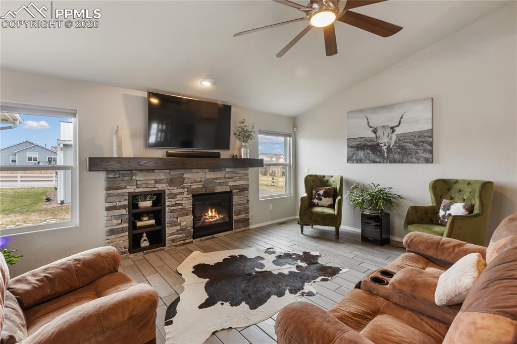 Image 3 of 41: Living area featuring a stone-faced fireplace with a wood-finish mantel and