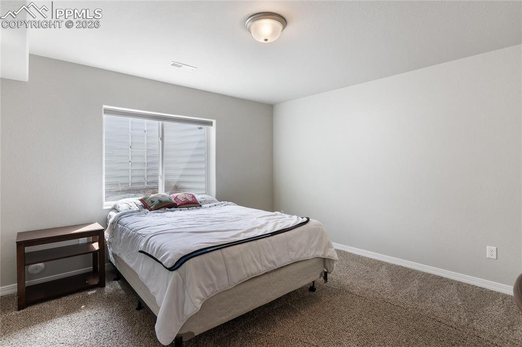 Image 30 of 41: Comfortable secondary bedroom with neutral finishes and natural light
