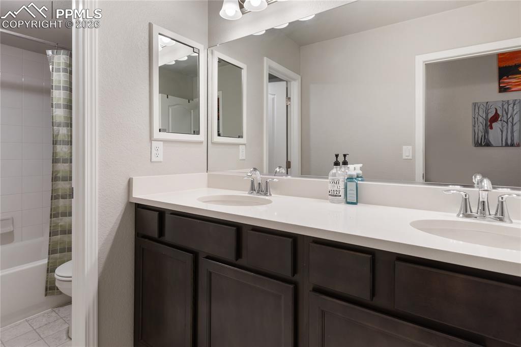 Image 31 of 41: Convenient laundry room with upper cabinetry and utility sink