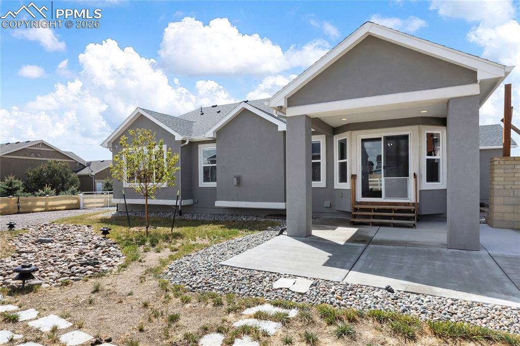Image 34 of 41: Rear exterior showcasing a covered patio with concrete flooring