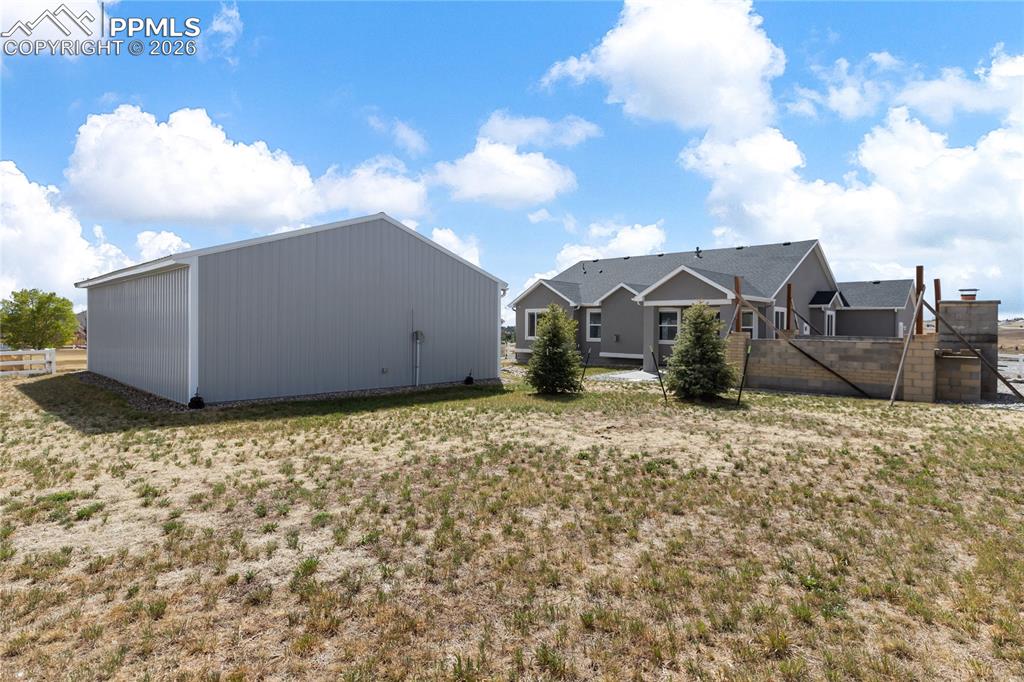 Image 35 of 41: Spacious property featuring a large shop with a gable roof, situated alongs
