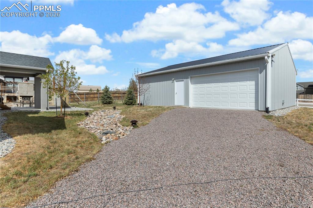 Image 36 of 41: Insulated shop with 240V power, overhead door, and gravel access