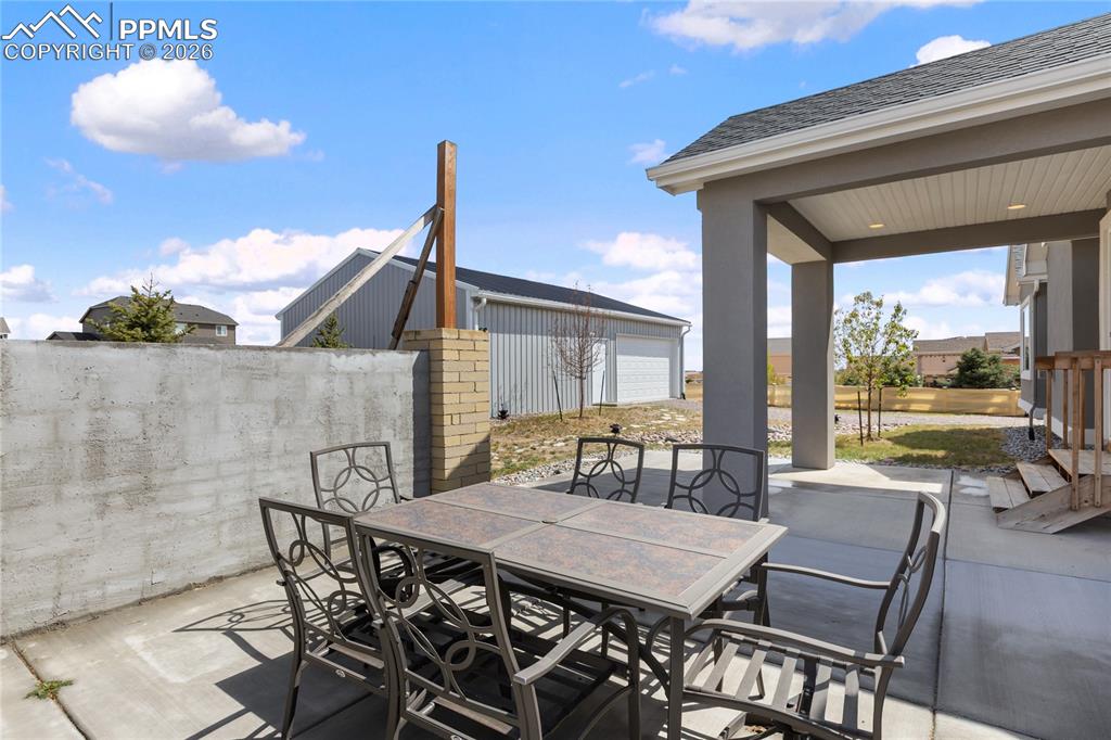 Image 38 of 41: Rear exterior showcasing a covered patio with concrete flooring