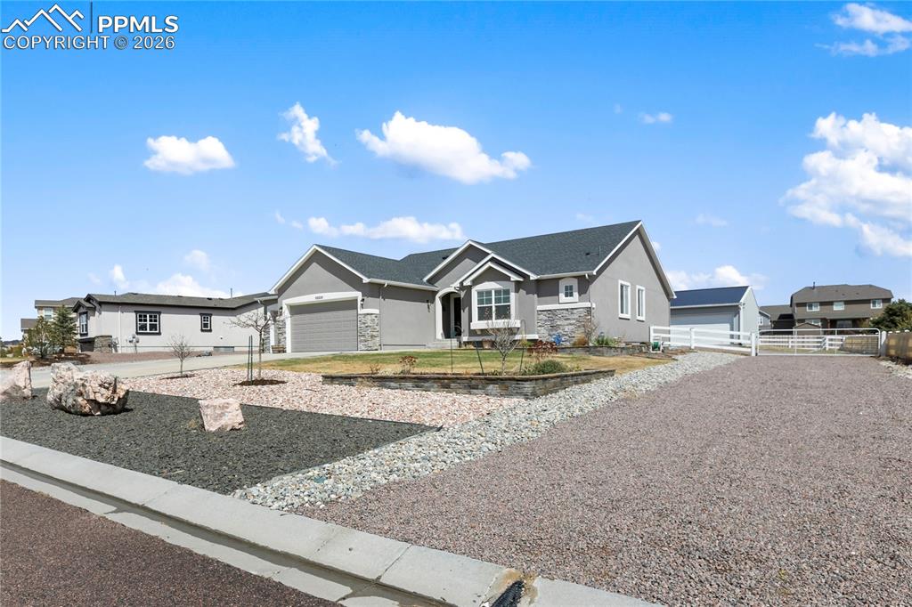 Image 41 of 41: Ranch-style residence featuring a gray stucco and stone veneer exterior