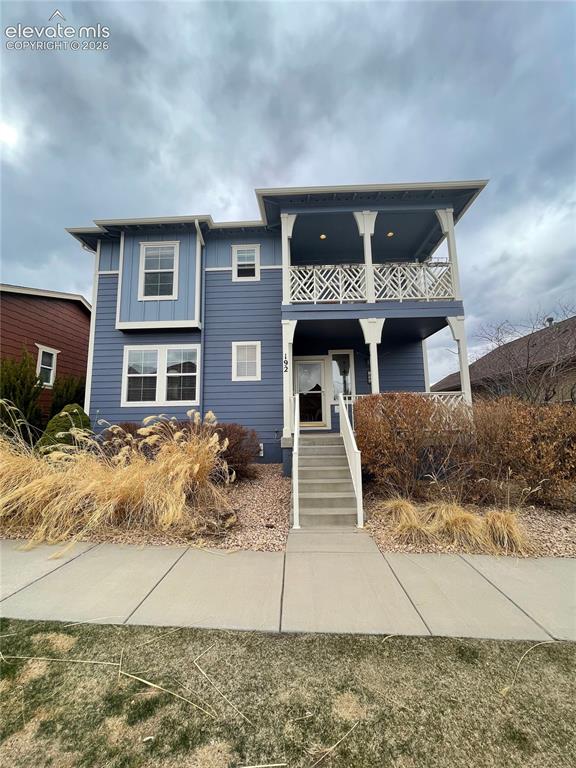 Image 1 of 27: Two-story exterior with siding, elevated porch with decorative railing, and