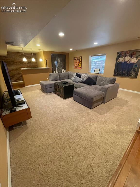 Image 18 of 27: Recessed lighting, light-colored carpeting, and a built-in bar area with pe