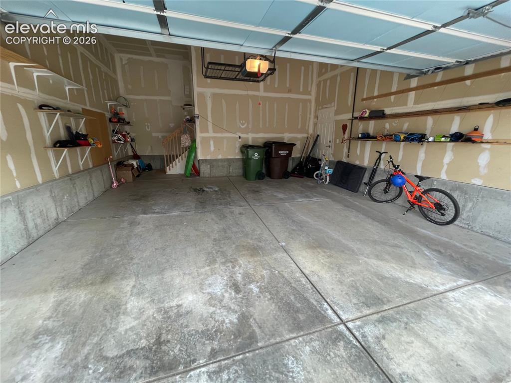 Image 19 of 27: Concrete flooring with integrated storage shelving and an overhead rack sys