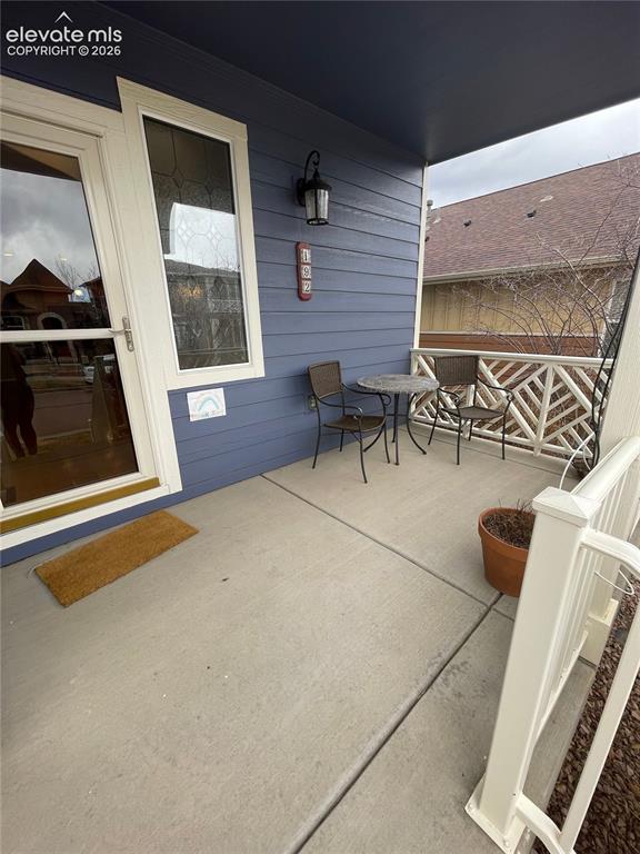 Image 2 of 27: Covered front porch featuring a decorative railing and a wall-mounted light