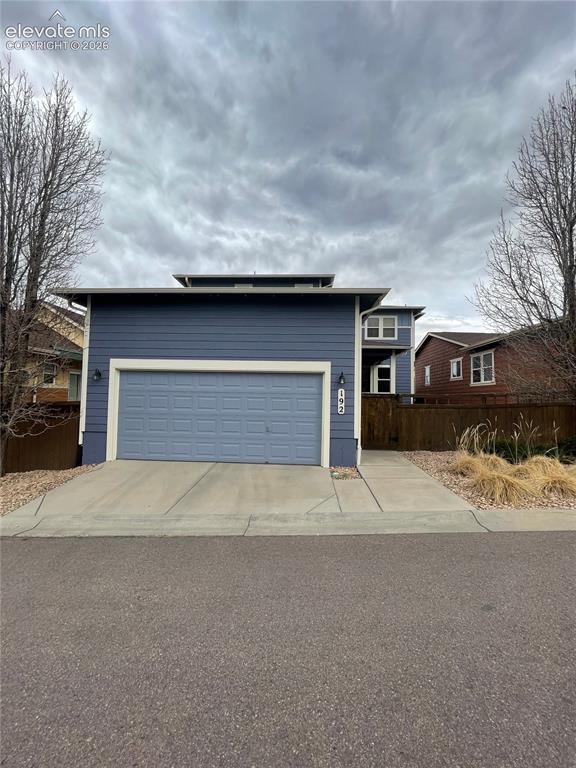 Image 20 of 27: Contemporary exterior with blue siding, an integrated garage, and modern ro