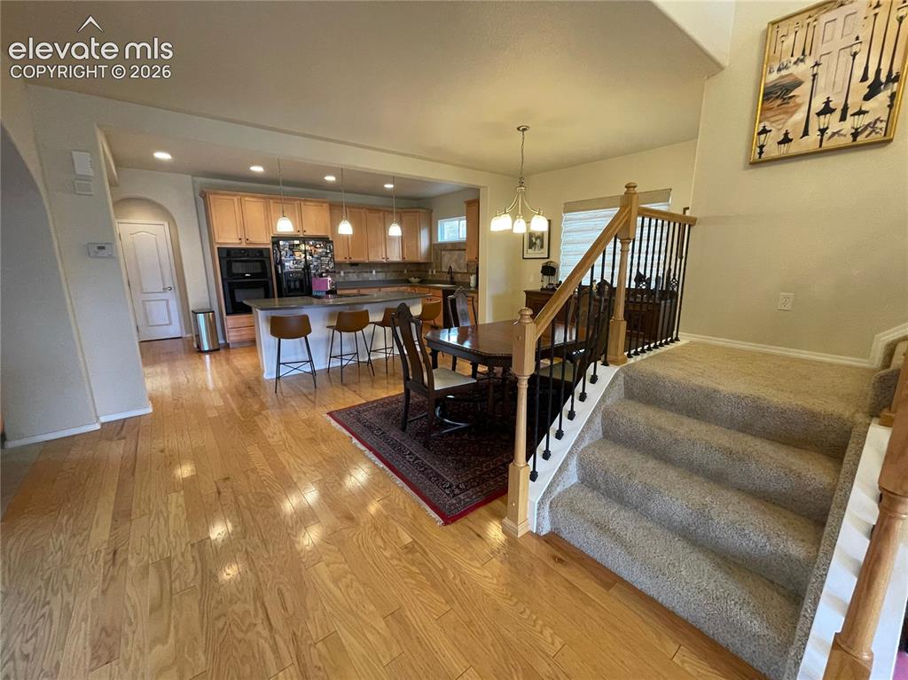Image 3 of 27: Hardwood flooring extending into the kitchen, kitchen island with built-in