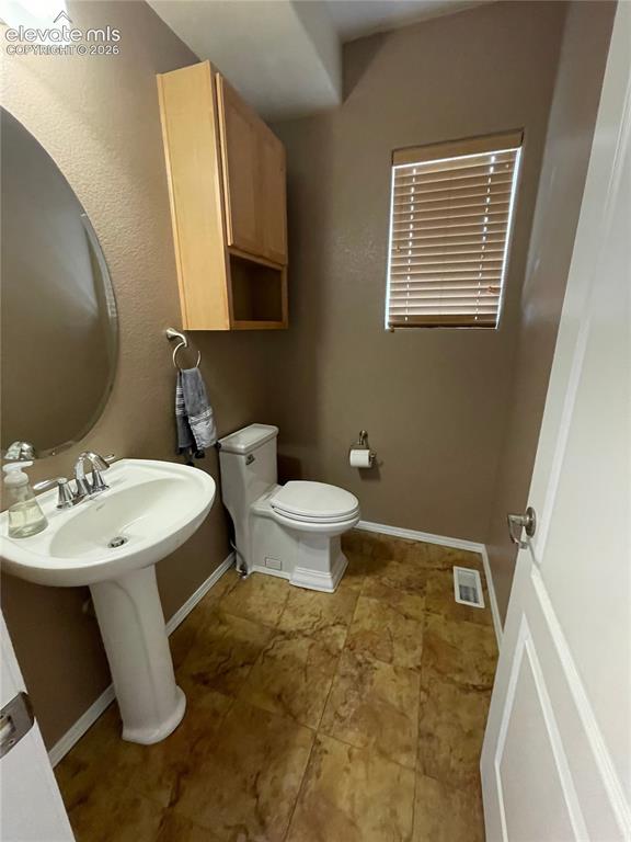 Image 8 of 27: Pedestal sink, wall-mounted vanity cabinet, window with blinds, and pattern