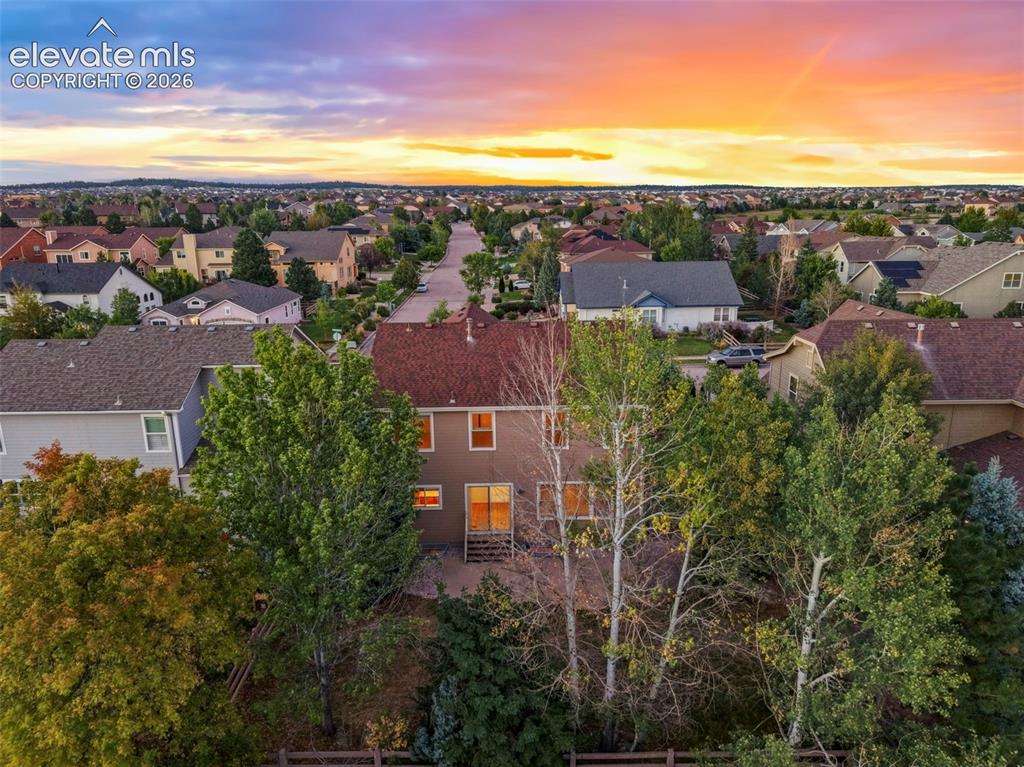 Image 28 of 34: Gorgeous twilight view of the back of the home featuring mature trees