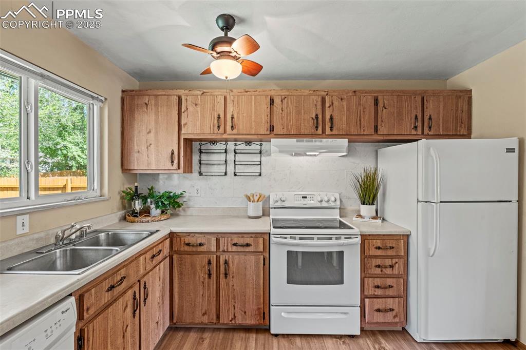 Image 13 of 41: Bright kitchen with light countertops. West facing window allows afternoon