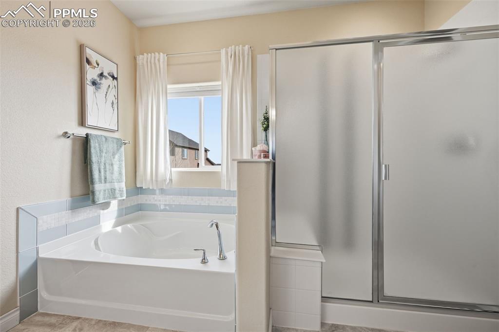 Image 31 of 45: Primary Bathroom Large Soaker Tub and Shower With Nice Bench.