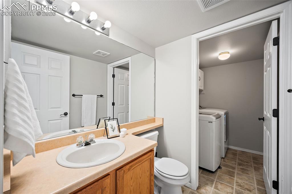 Image 13 of 46: Bathroom with vanity and washer and dryer