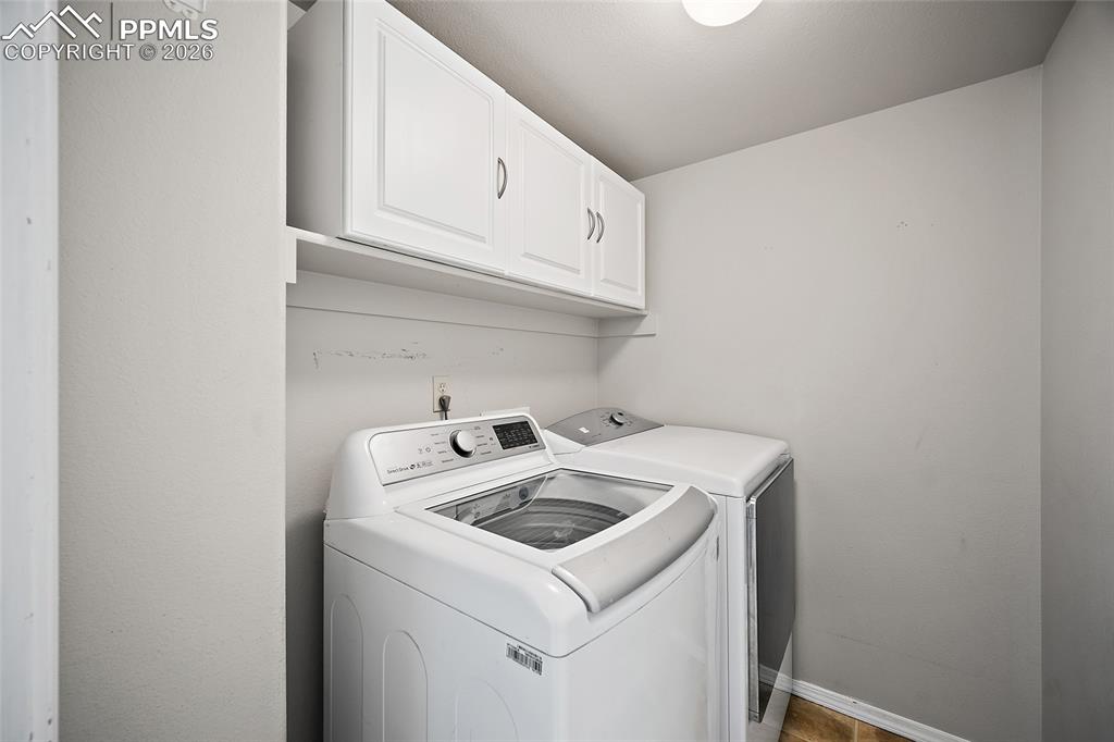 Image 14 of 46: Laundry room with cabinet space and washing machine and dryer