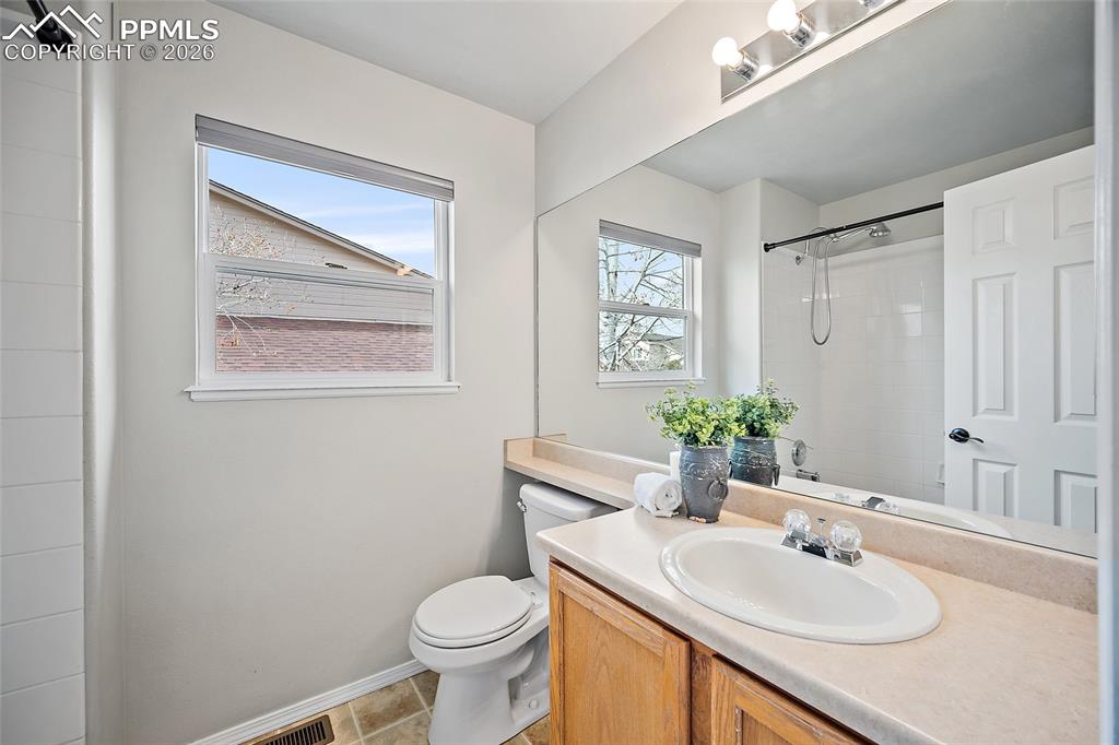 Image 20 of 46: Bathroom with vanity, a shower, and light tile patterned flooring