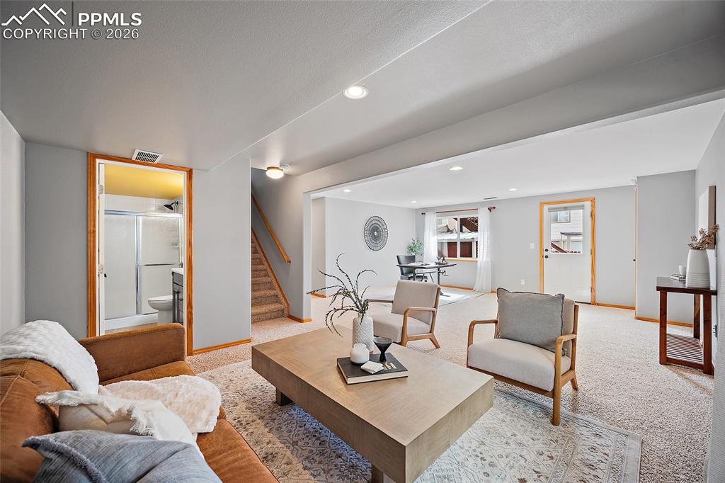 Image 23 of 46: Living area with light carpet and recessed lighting