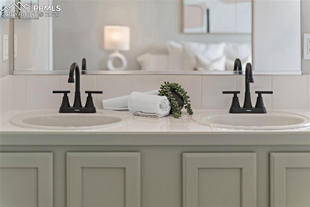 Image 36 of 46: Bathroom view of double vanity and decorative backsplash