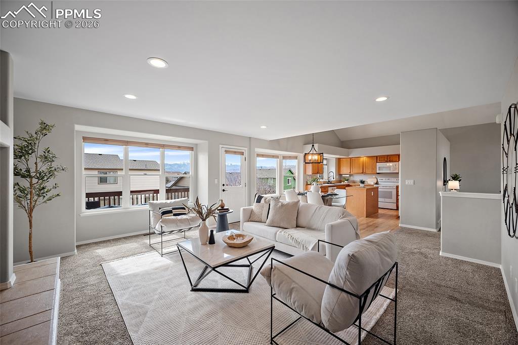 Image 9 of 46: Living area with light carpet and recessed lighting