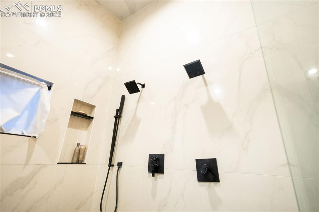 Image 17 of 44: Bathroom view of a marble finish shower