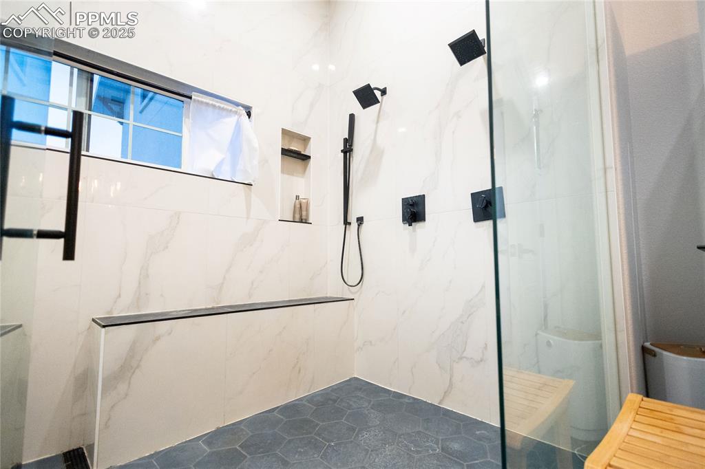 Image 18 of 44: Bathroom with a marble finish shower
