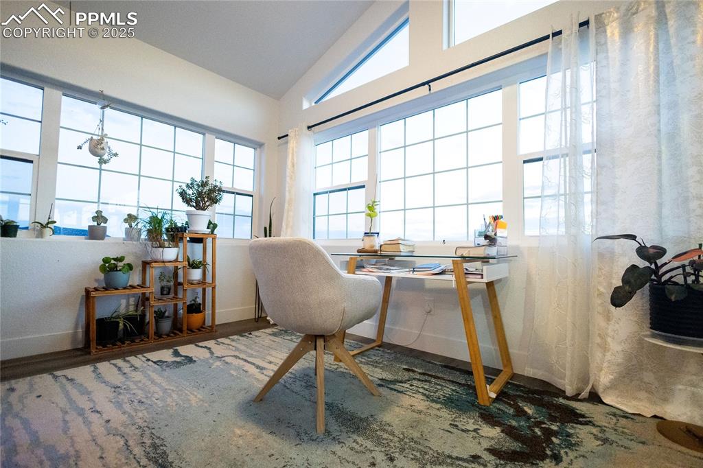 Image 23 of 44: Office with vaulted ceiling and wood finished floors