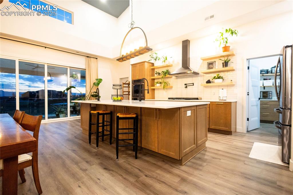 Image 3 of 44: Kitchen featuring open shelves, tasteful backsplash, brown cabinets, decora