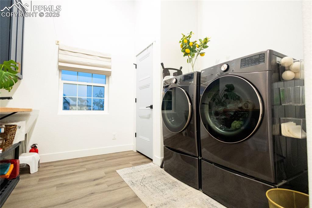 Image 31 of 44: Main level Laundry area featuring light wood finished floors and separate w