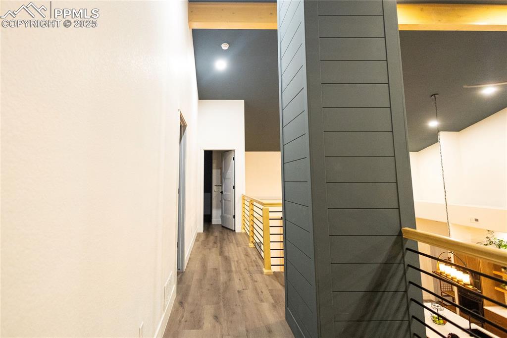 Image 33 of 44: Hallway featuring wood finished floors and a towering ceiling