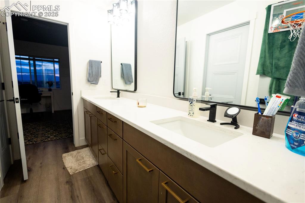 Image 35 of 44: Bathroom featuring double vanity and dark wood-type flooring