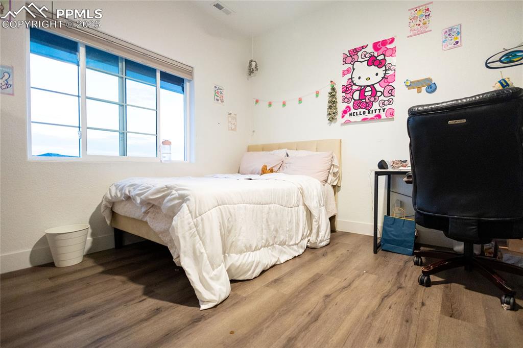 Image 36 of 44: Bedroom 5 featuring an office area and wood finished floors