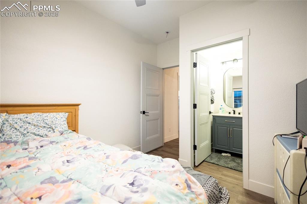 Image 37 of 44: Bedroom 6 featuring light wood-type flooring, ensuite bathroom, and a ceili