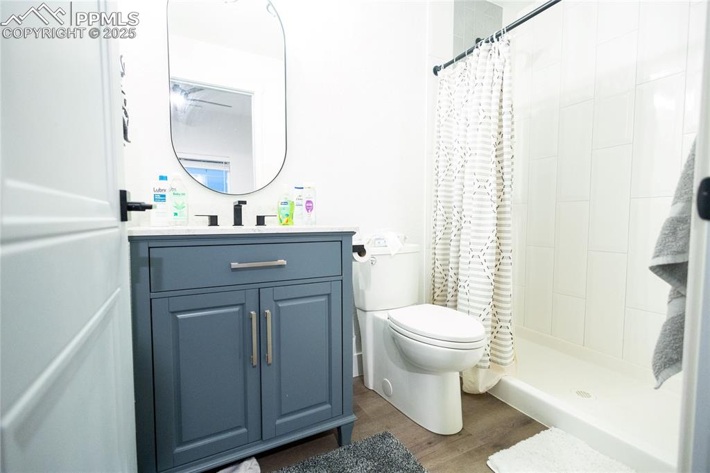 Image 38 of 44: Bathroom inside the 6th bedroom featuring vanity, a stall shower, and dark