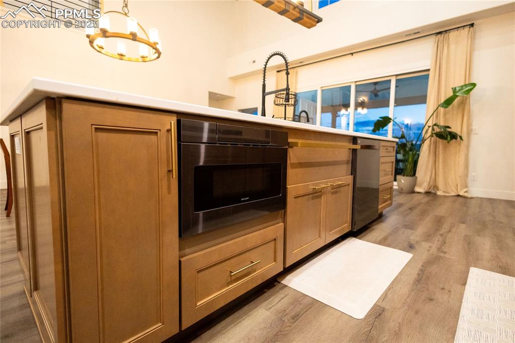 Image 39 of 44: Kitchen with light wood-style floors, appliances with stainless steel finis