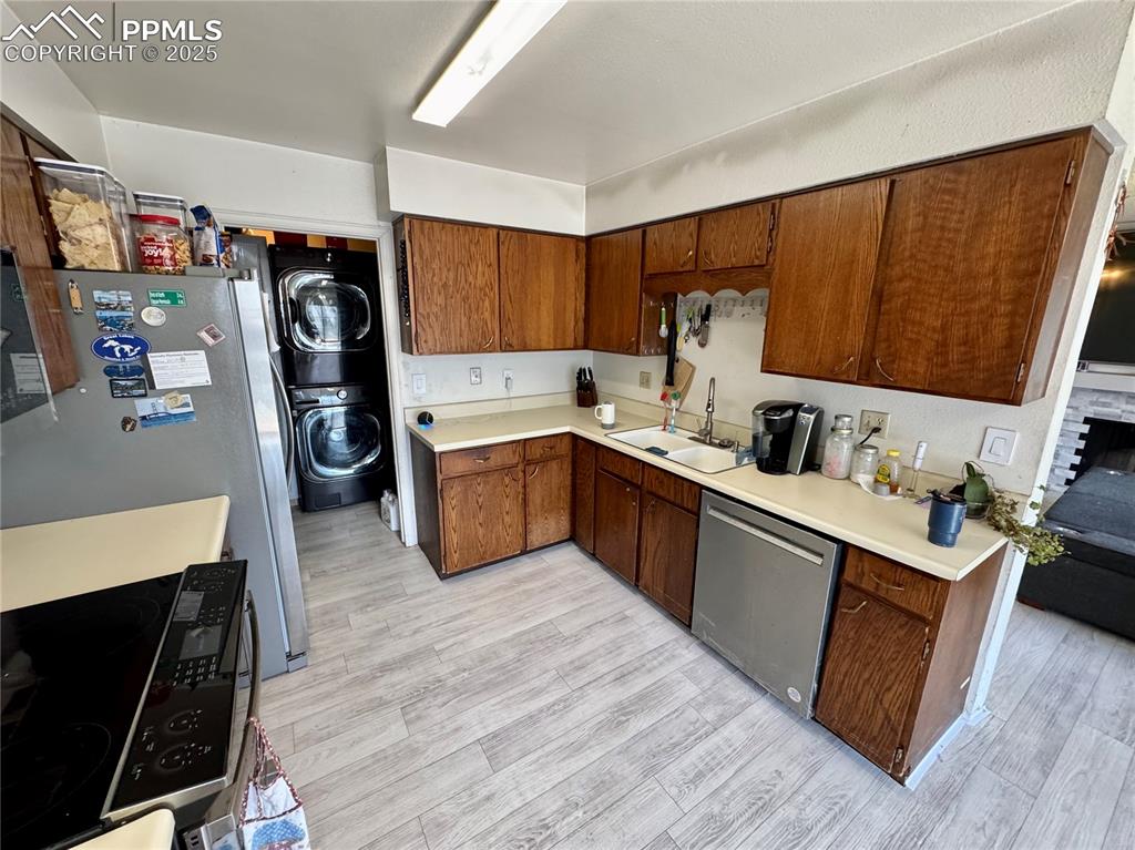 Image 11 of 22: Kitchen with stacked washer and clothes dryer, light countertops, appliance