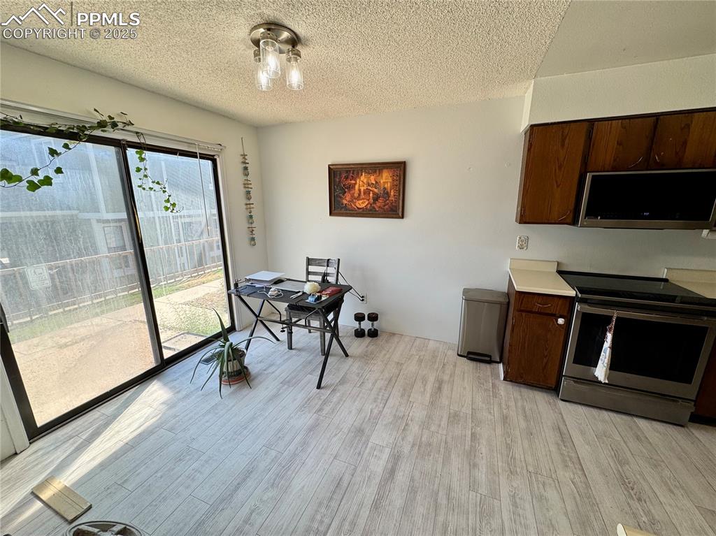 Image 12 of 22: Kitchen with appliances with stainless steel finishes, light countertops, d